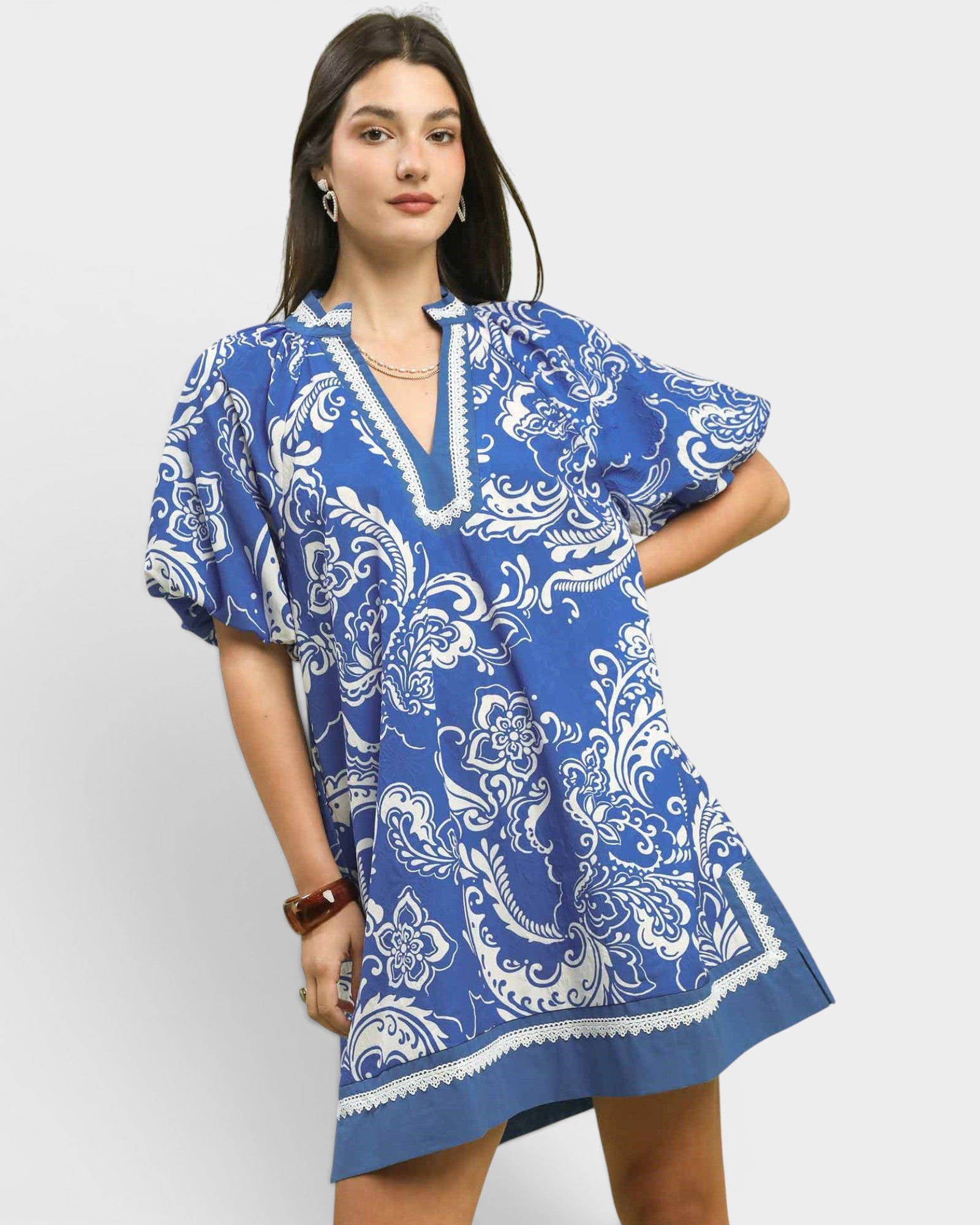 Woman wearing a blue and white patterned dress on a white background