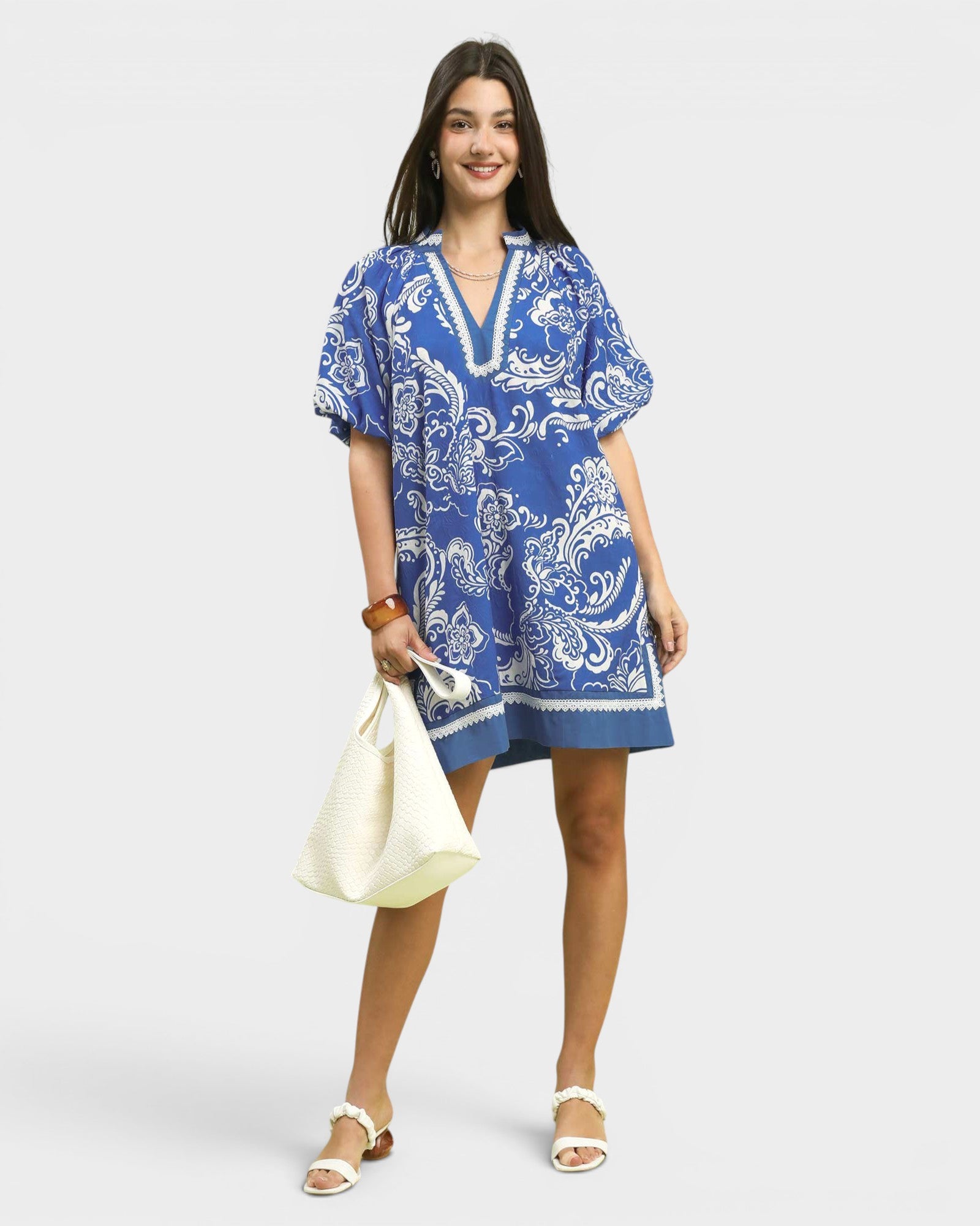 Woman wearing a blue and white patterned dress on a white background