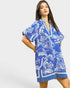 Woman wearing a blue and white patterned dress on a plain background