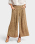 Person wearing beige patterned wide-leg pants on a white background