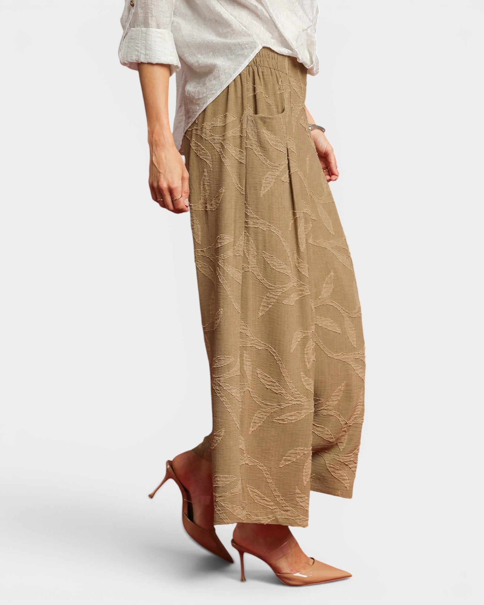 Beige wide-leg pants worn by a person on a white background