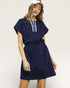 Woman wearing a navy blue dress with a white background