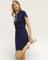 Woman wearing a navy blue dress with a white background