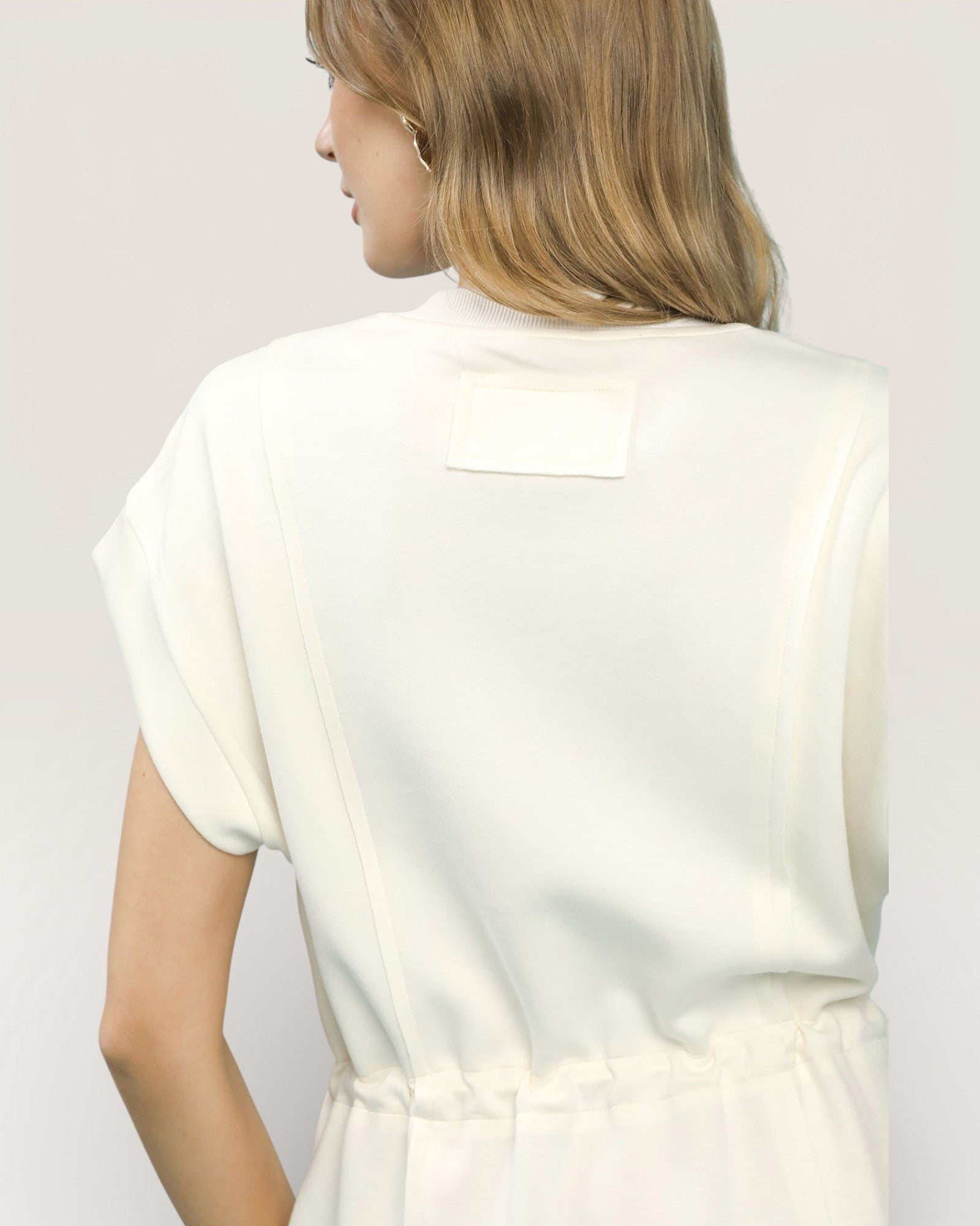 Woman wearing a white blouse against a plain background