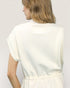 Woman wearing a white blouse against a plain background
