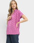 Woman wearing a pink lace top and blue pants on a white background