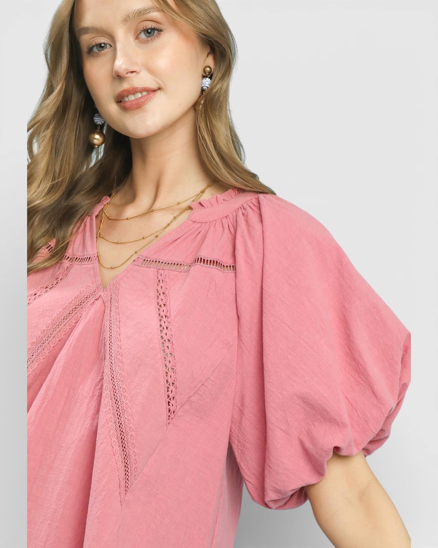 Woman wearing a pink blouse with a plain background