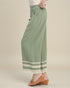 Green pants with white lace trim worn by a person on a beige background