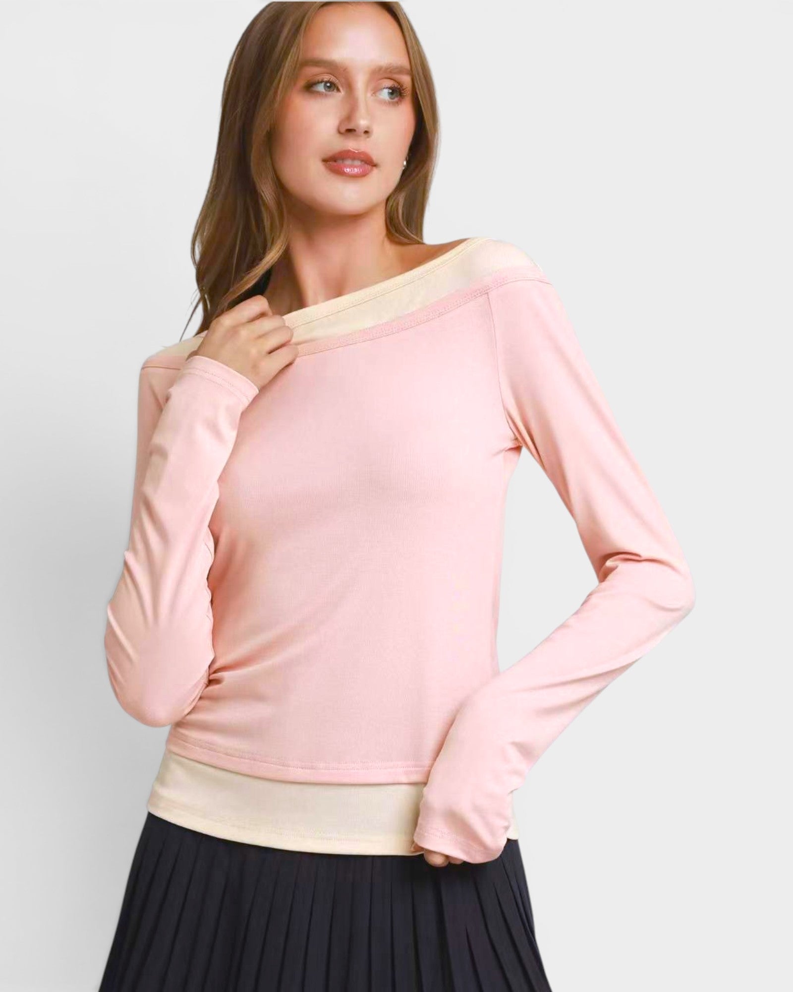 Woman wearing a pink sweater with a plain background
