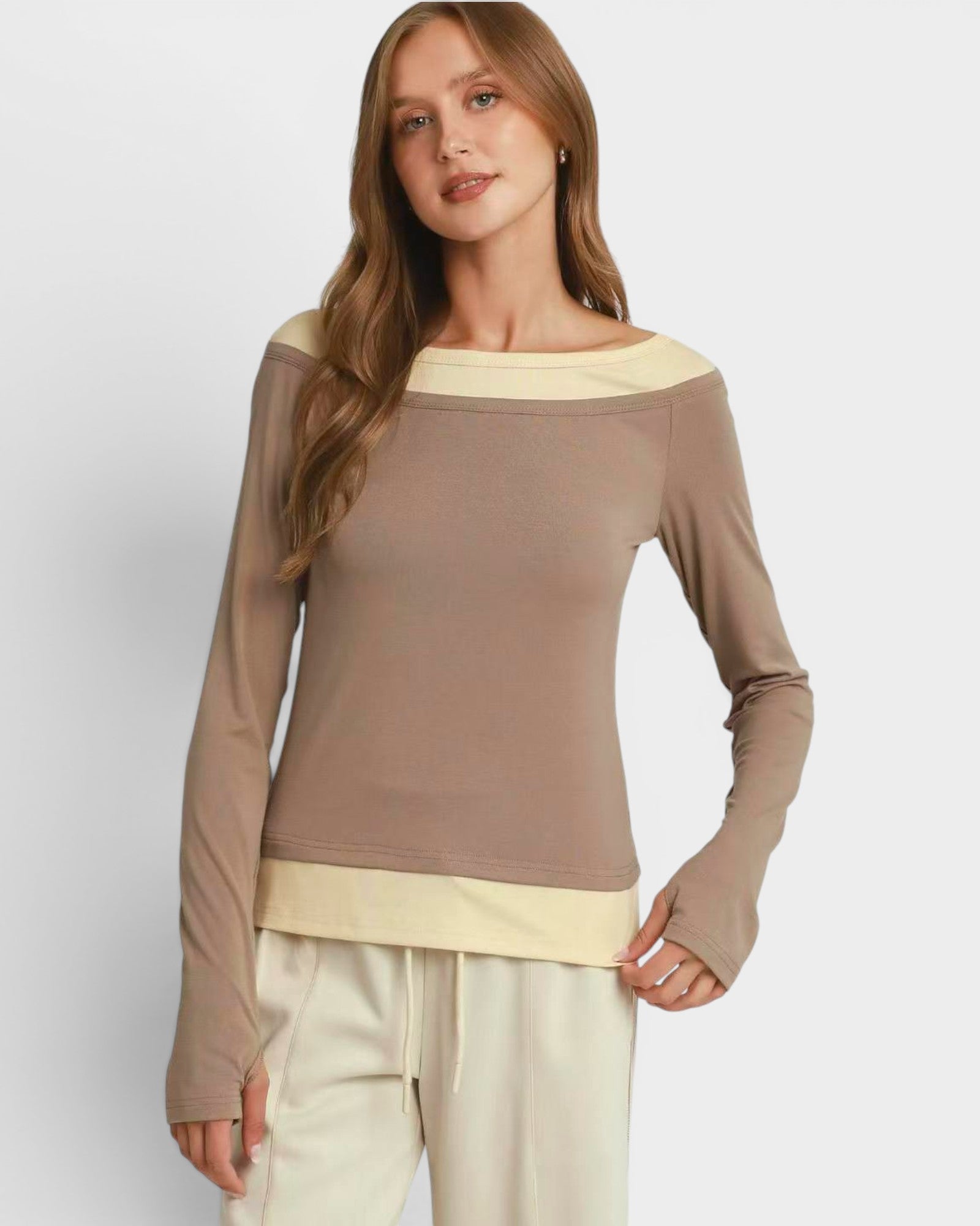 Woman wearing a brown long-sleeve top with a white background