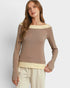 Woman wearing a brown long-sleeve top with a white background