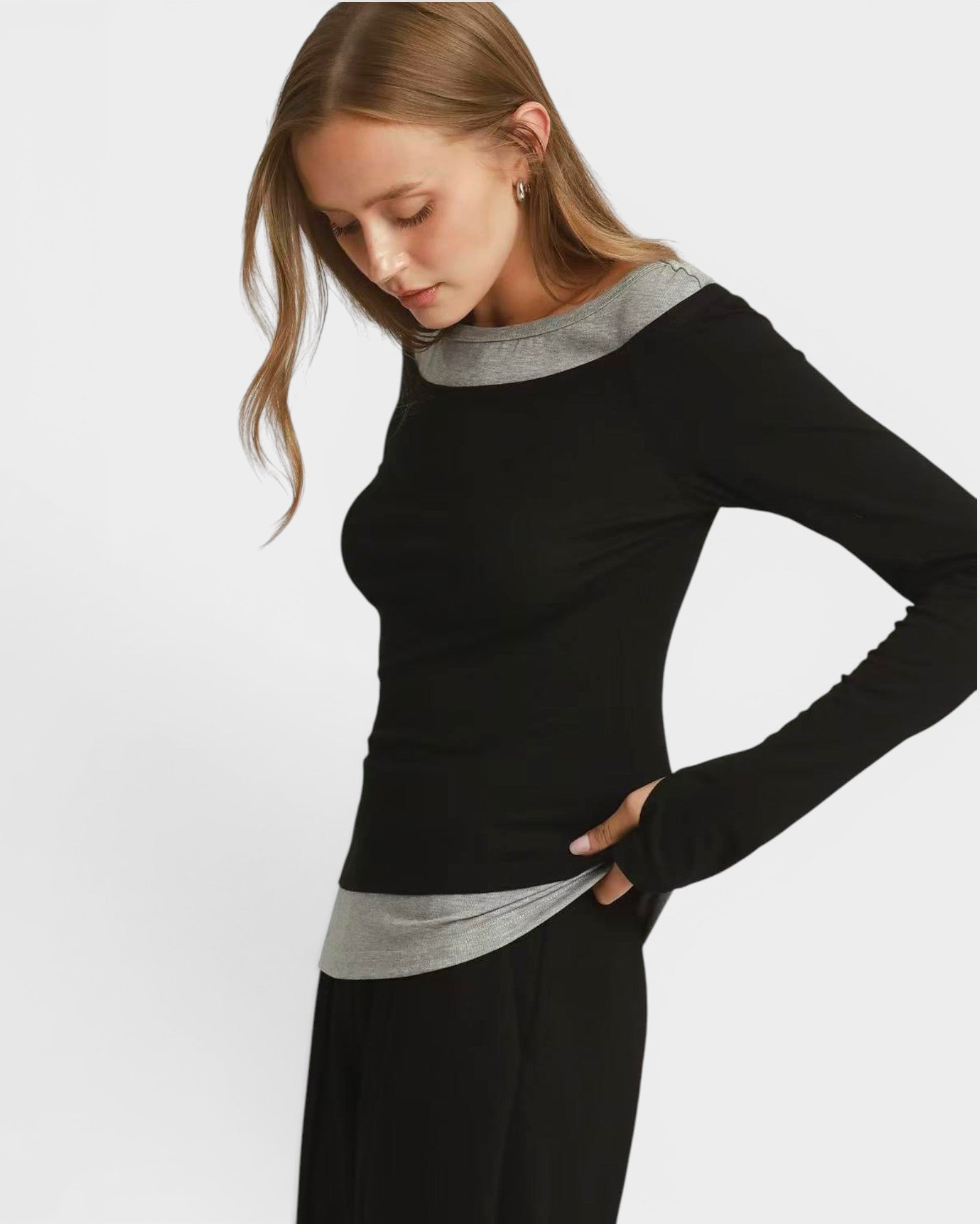 Woman wearing a black top with gray accents on a white background