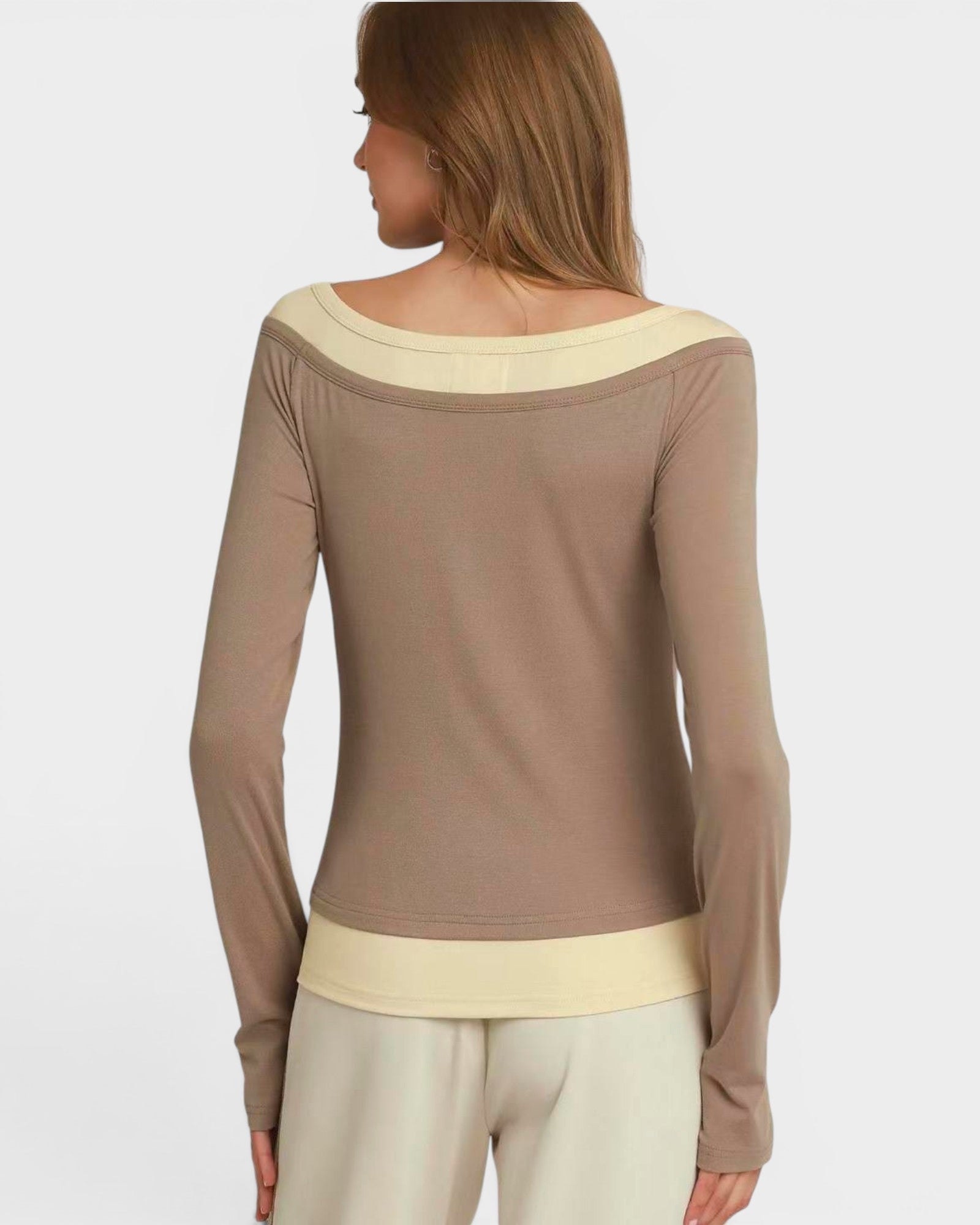 Woman wearing a brown long-sleeve top with a cream collar on a white background