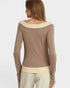 Woman wearing a brown long-sleeve top with a cream collar on a white background