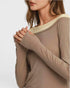 Close-up of a person wearing a beige long-sleeve top on a white background