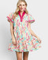 Woman wearing a colorful patterned dress with a pink collar on a white background