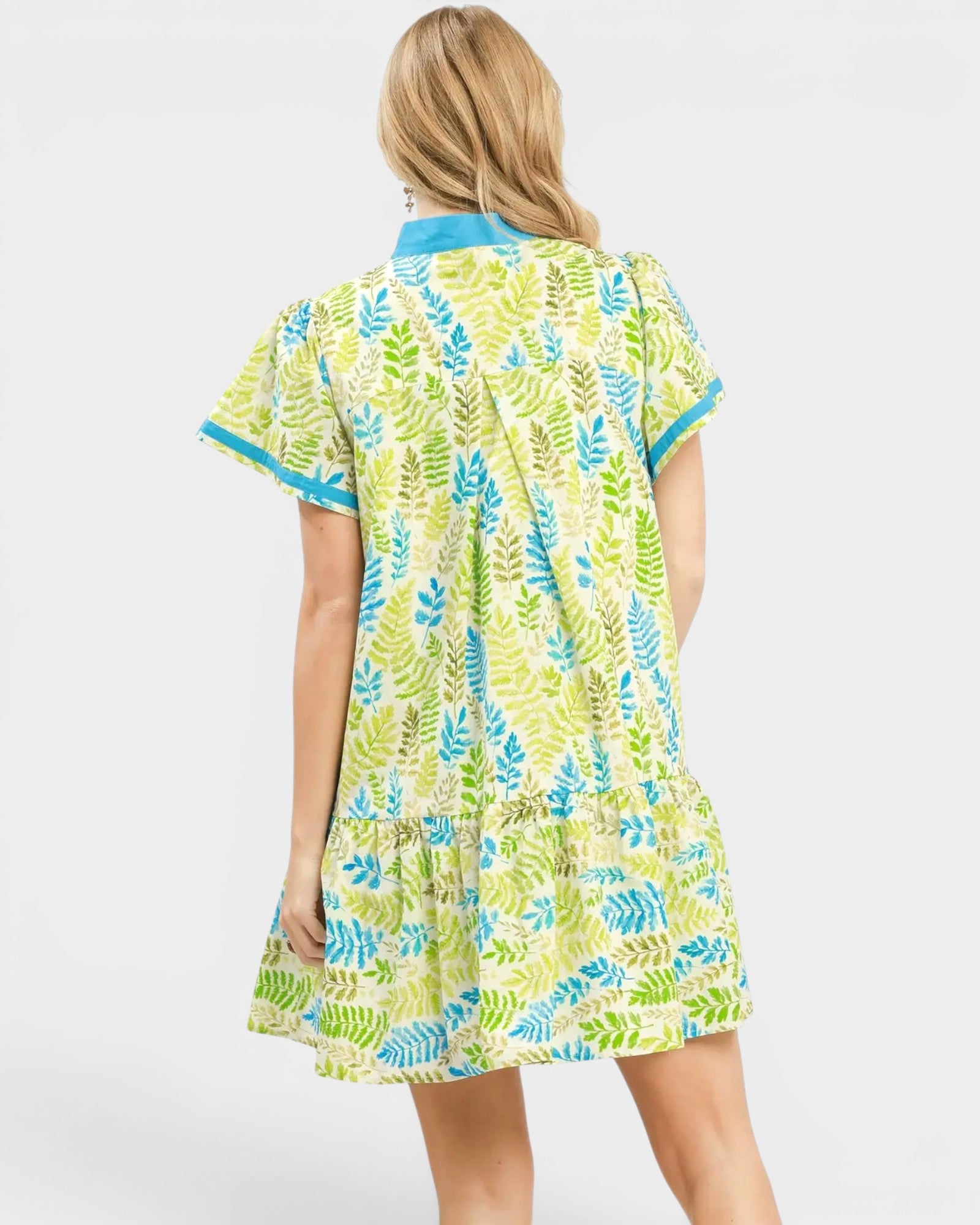 Woman wearing a green and blue patterned dress on a white background