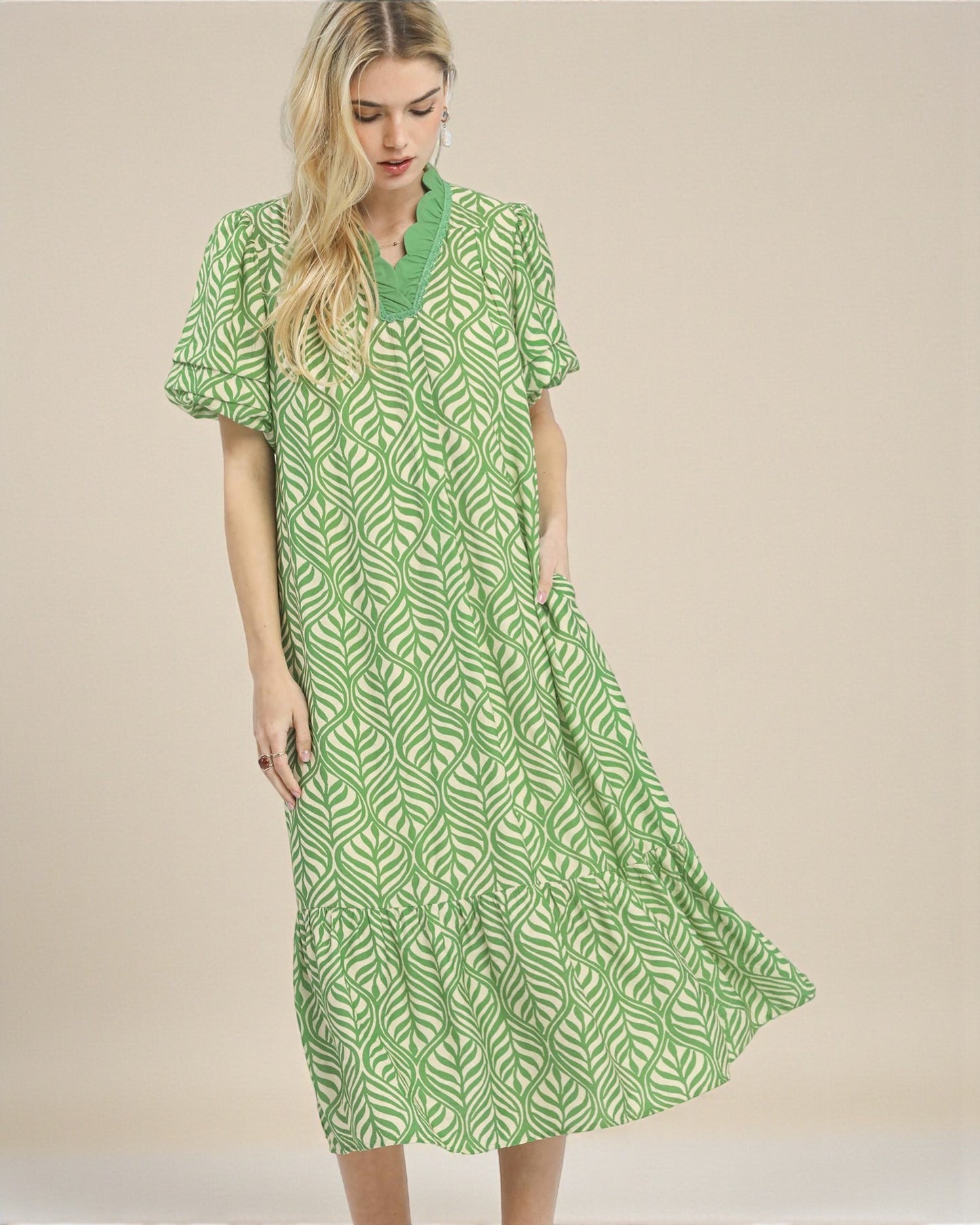 Woman wearing a green patterned dress on a beige background