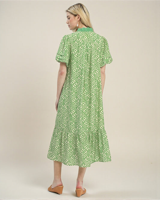 Woman wearing a green patterned dress on a beige background