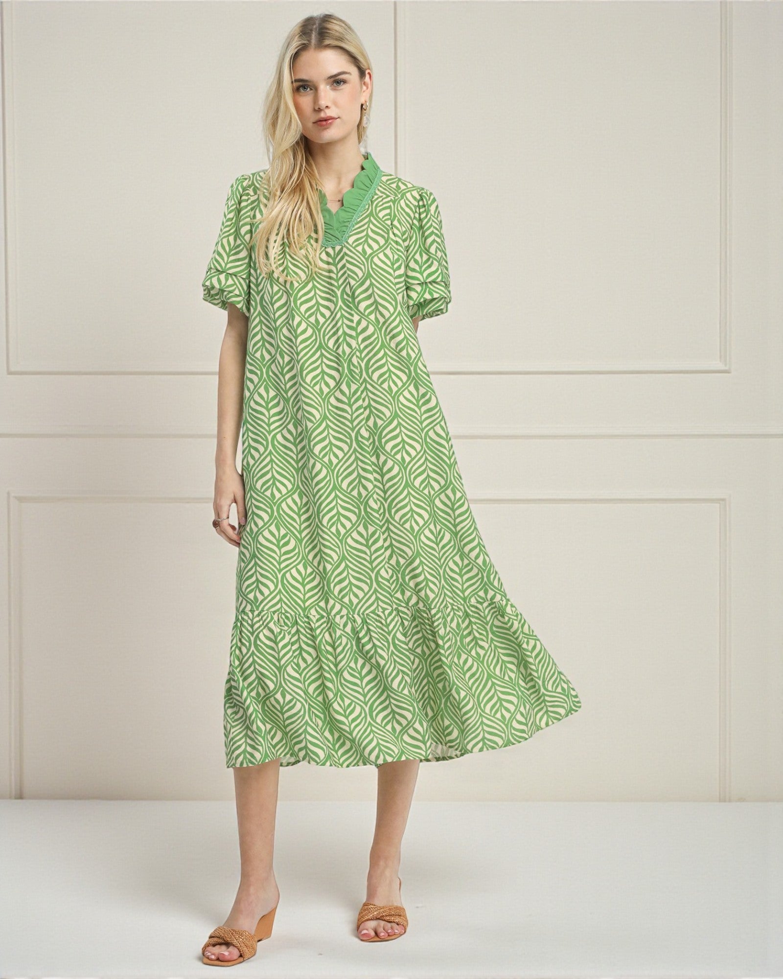 Woman wearing a green patterned dress against a white background
