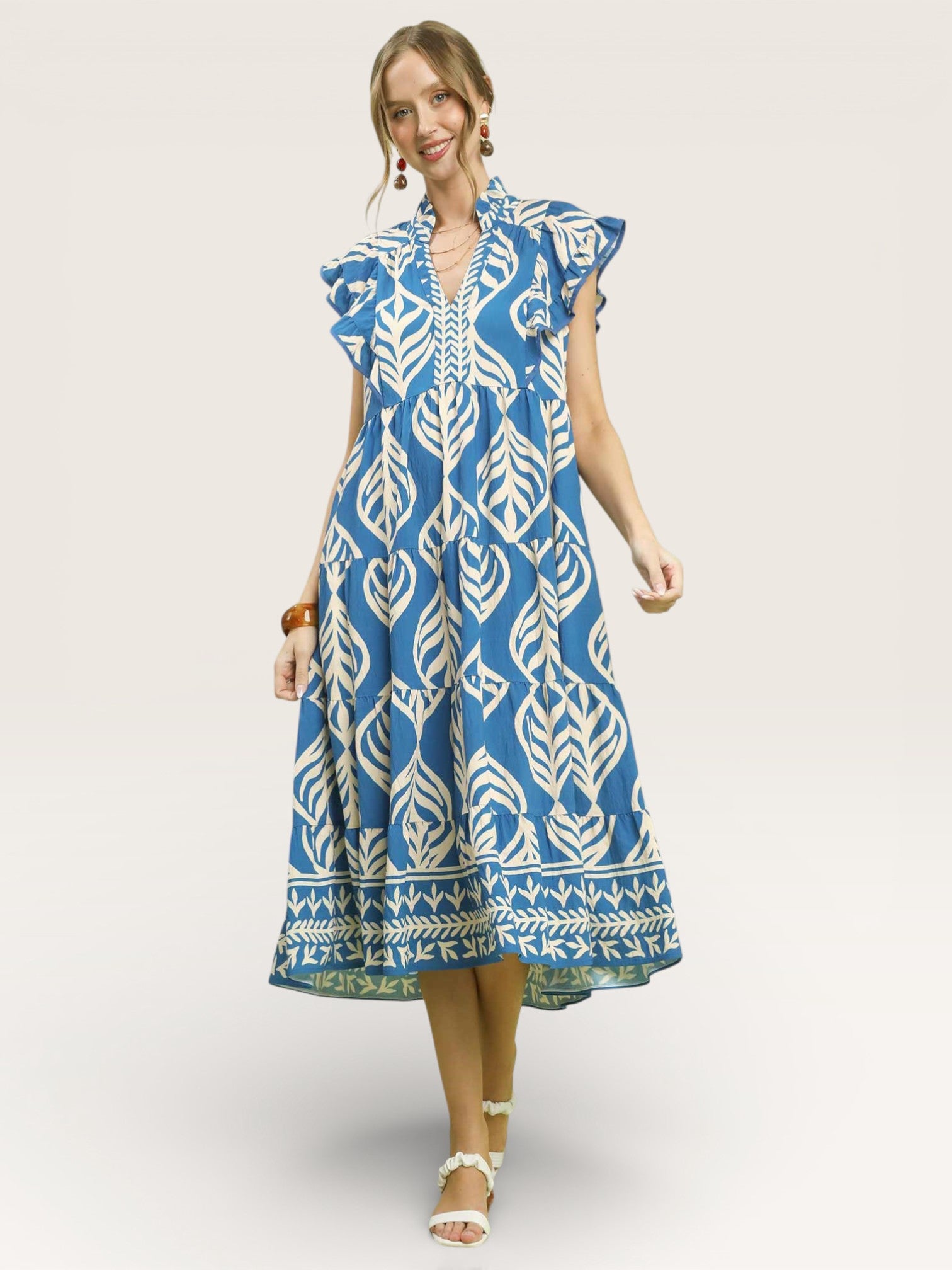 Woman wearing a blue and white patterned dress on a plain background