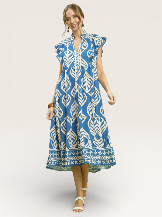 Woman wearing a blue and white patterned dress on a plain background