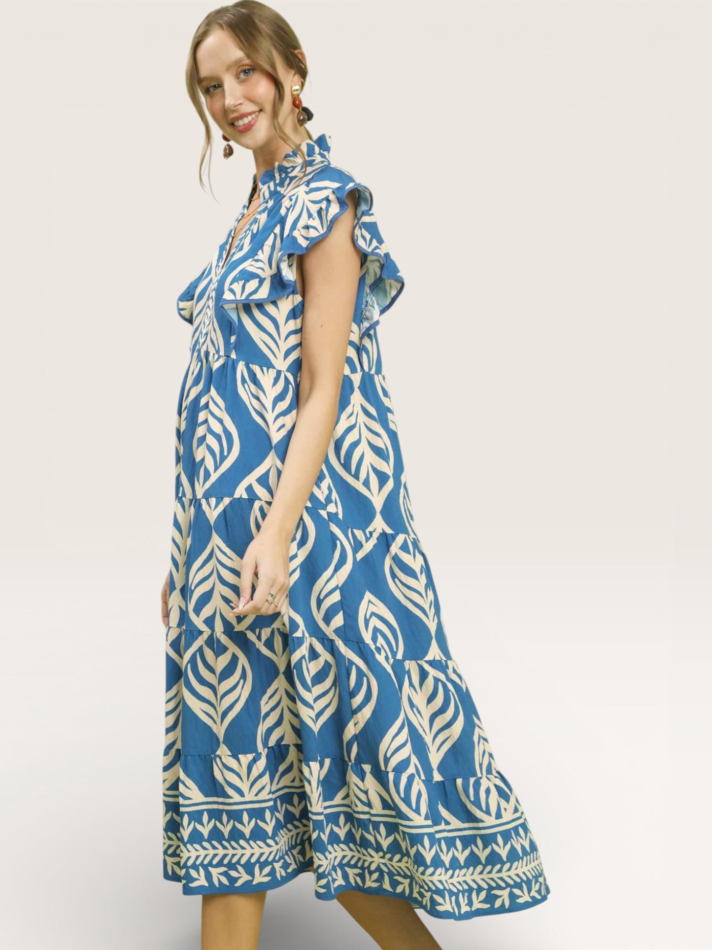 Woman wearing a blue and white patterned dress on a plain background