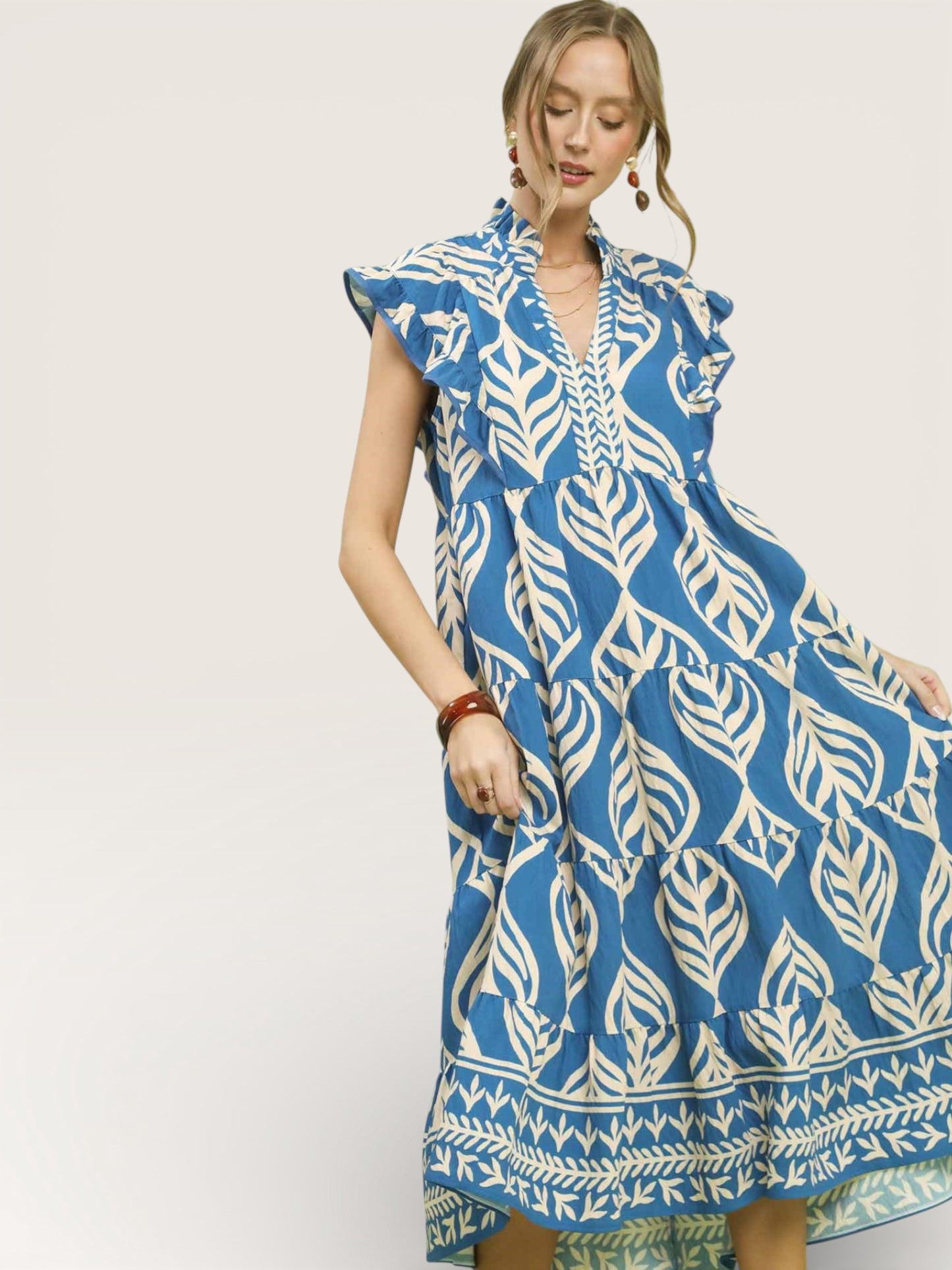 Woman wearing a blue and white patterned dress on a plain background