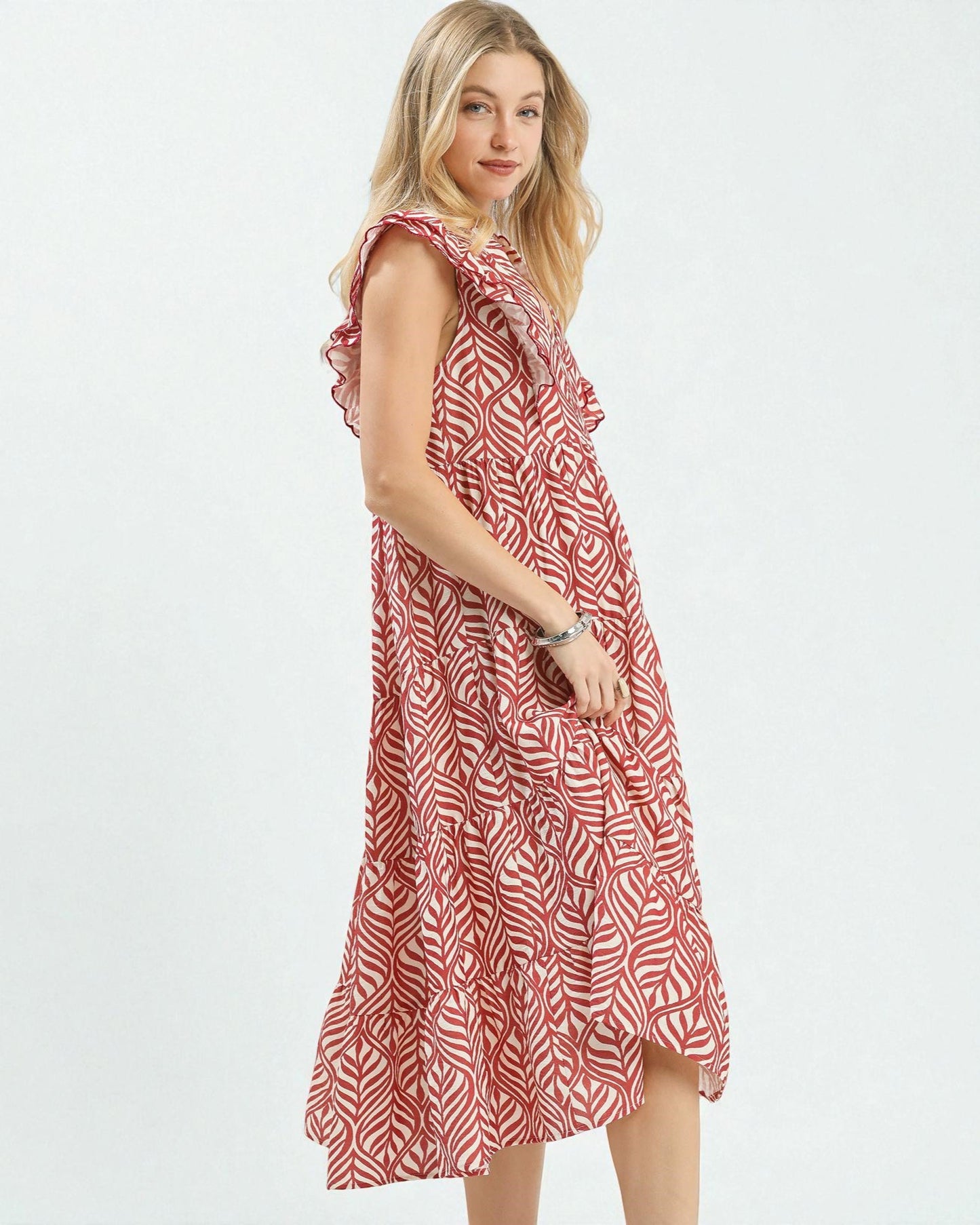 Woman wearing a red and white patterned dress on a white background