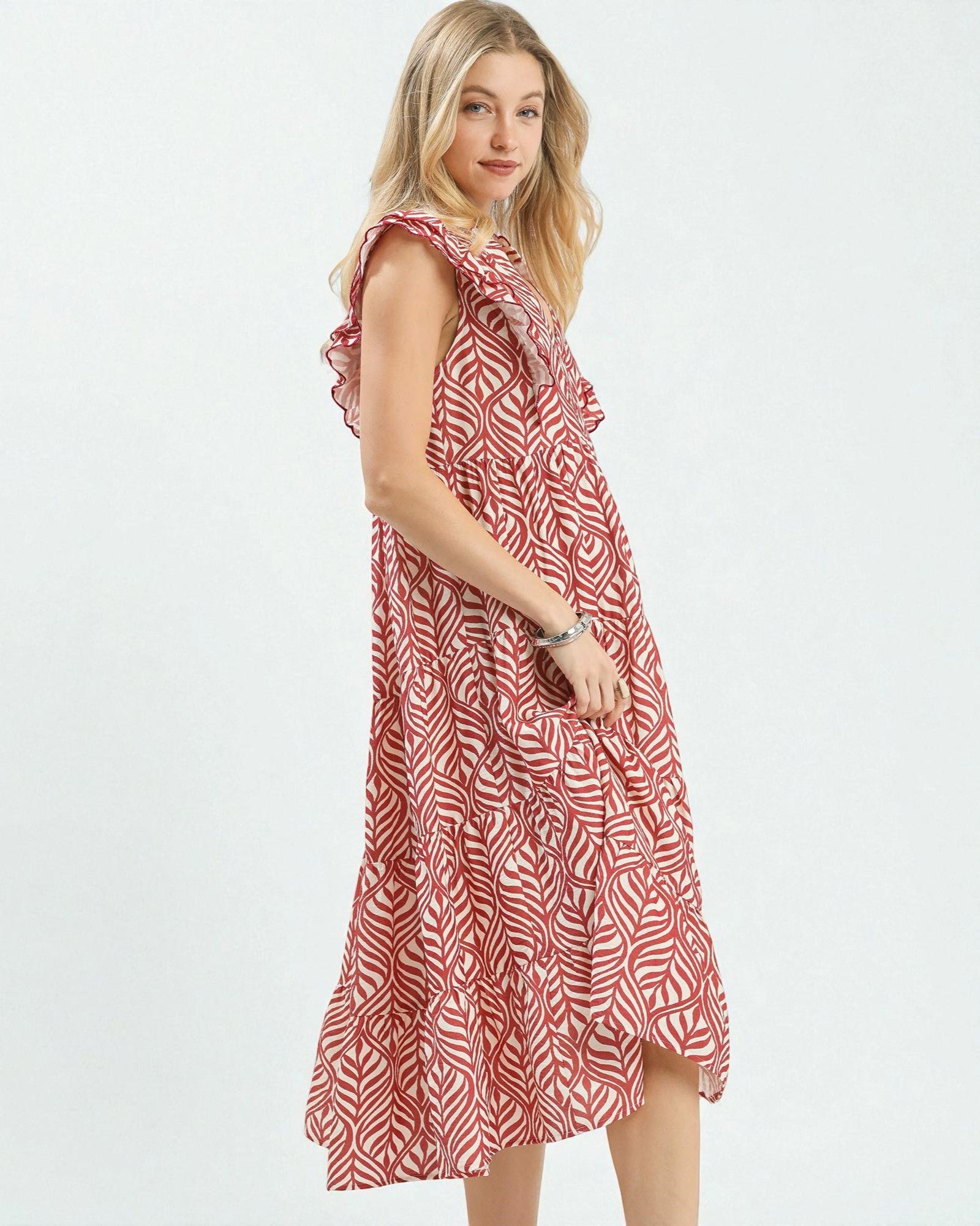 Woman wearing a red and white patterned dress on a white background