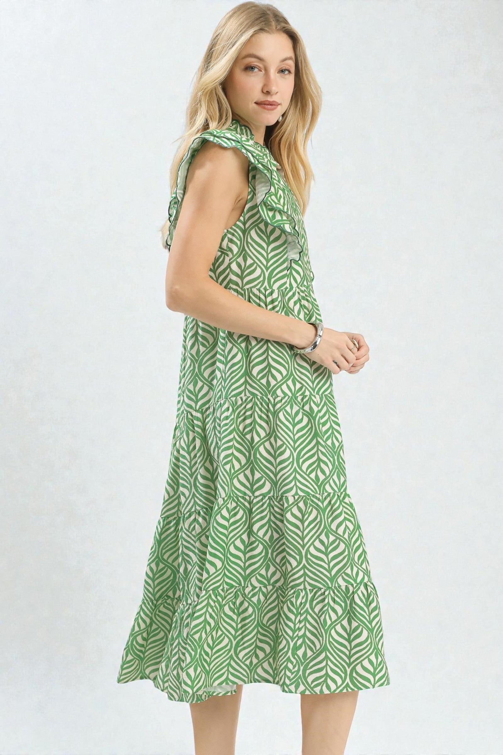 Woman wearing a green patterned dress on a white background