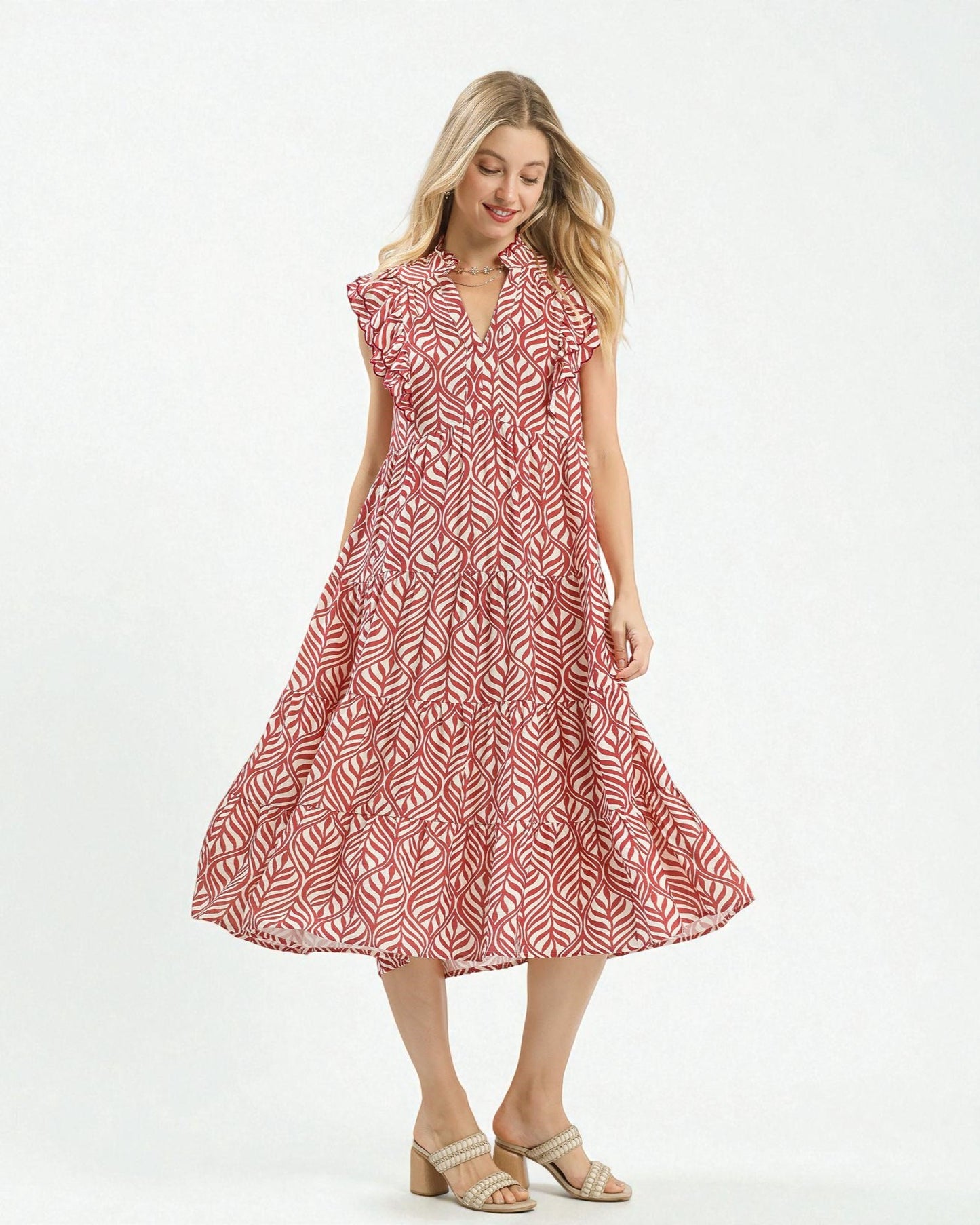 Woman wearing a red and white patterned dress on a white background