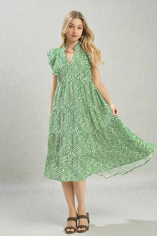 Woman wearing a green patterned dress on a plain background