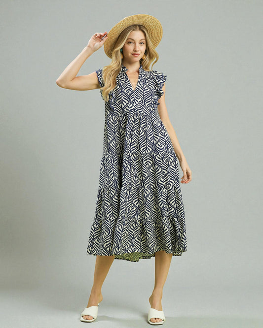 Woman wearing a patterned dress and straw hat on a plain background