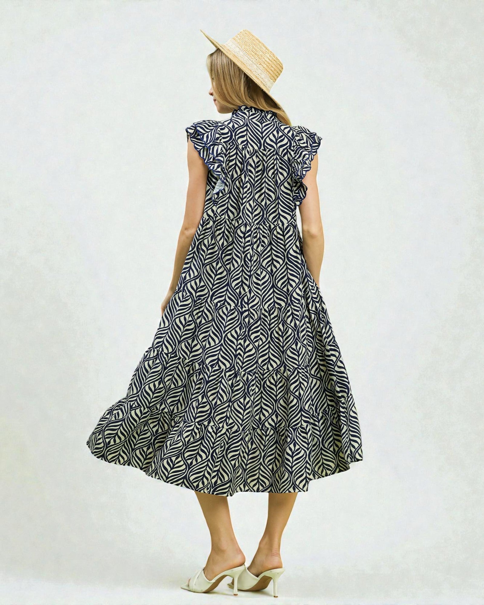 Woman wearing a black and white patterned dress on a white background