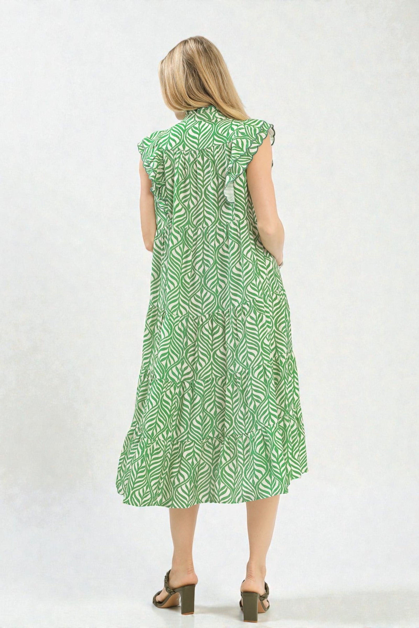 Woman wearing a green patterned dress on a white background