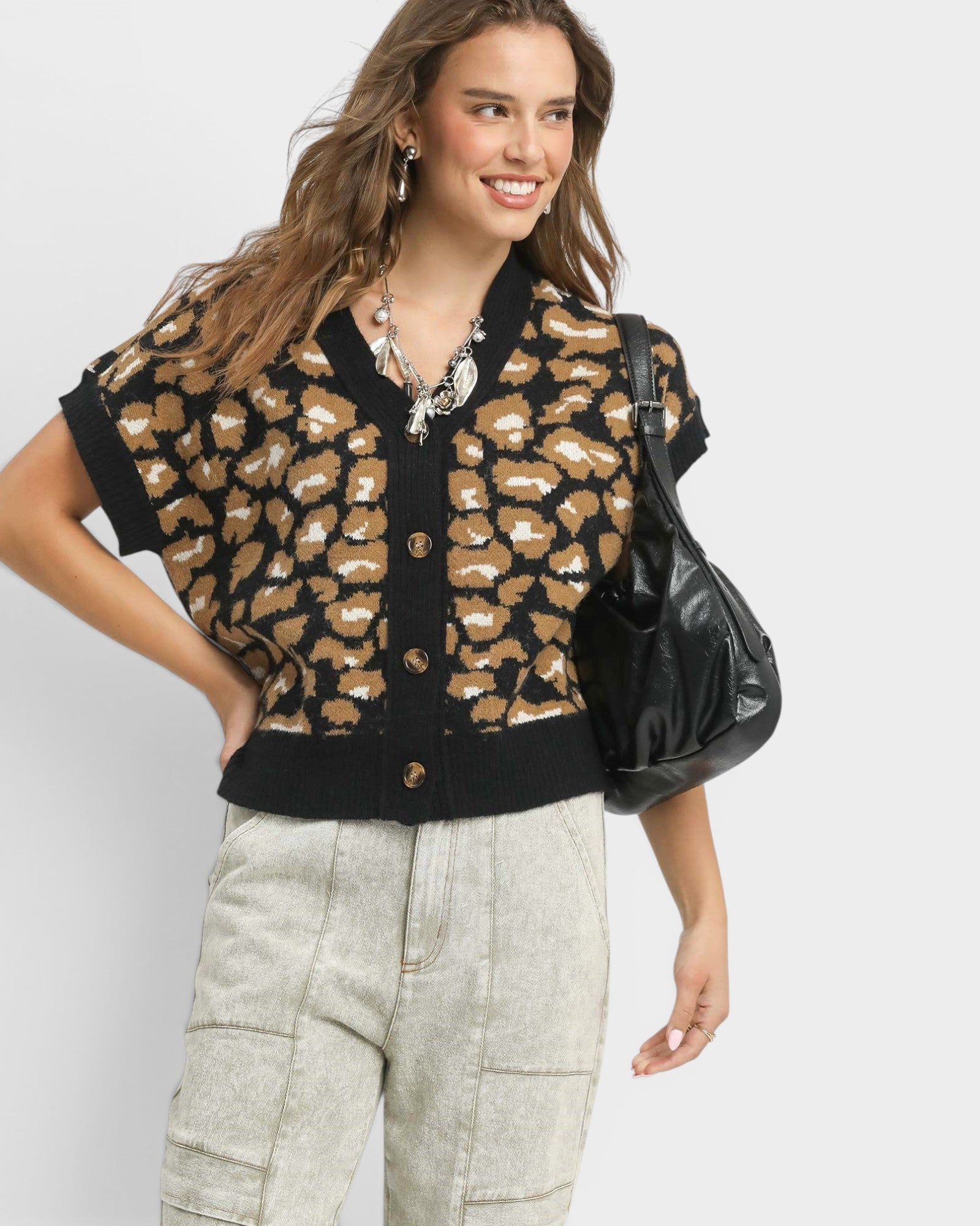 Woman wearing a leopard print cardigan with a plain background
