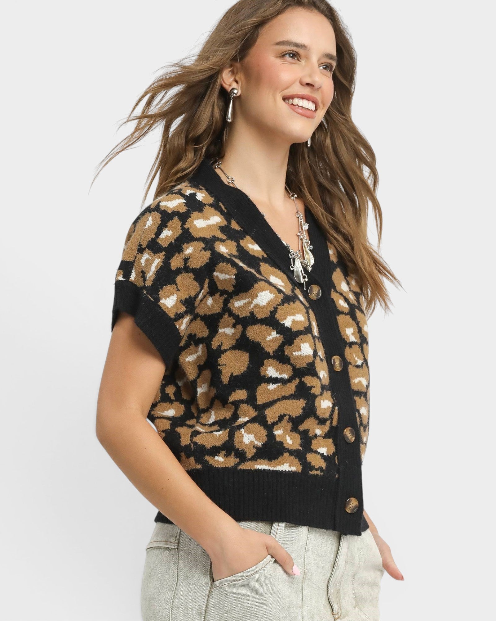 Woman wearing a leopard print cardigan against a white background