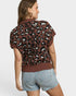 Woman wearing a leopard print sweater and denim shorts on a white background