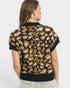 Person wearing a leopard print sweater on a plain background