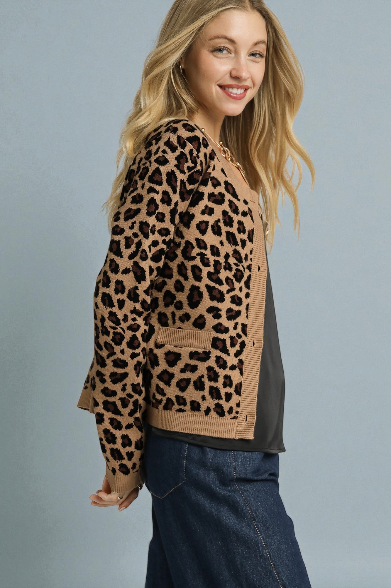 Woman wearing a leopard print sweater with a plain background