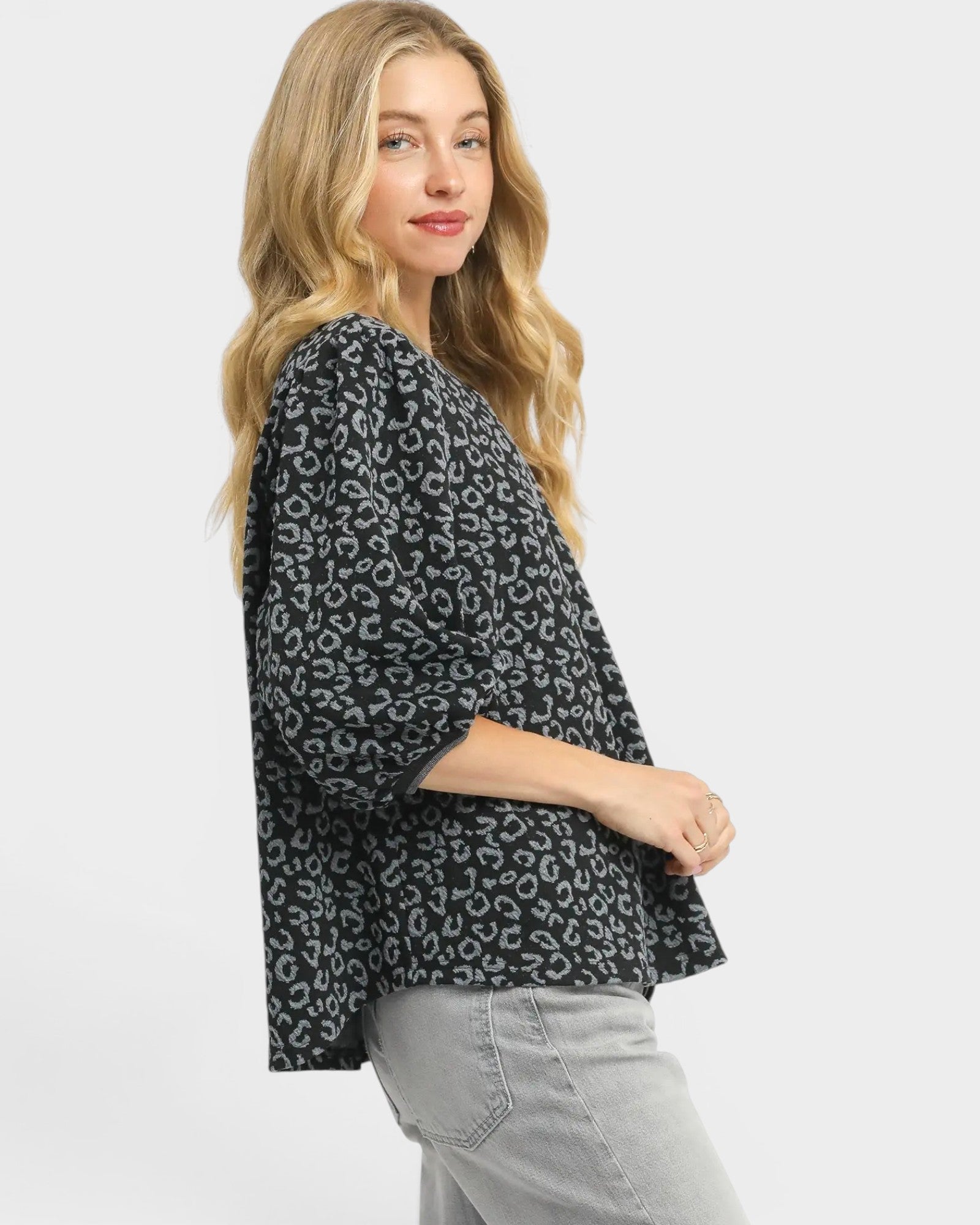 Woman wearing a black leopard print jacket on a white background