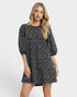 Woman wearing a black patterned dress on a white background