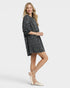 Woman wearing a black patterned dress on a white background