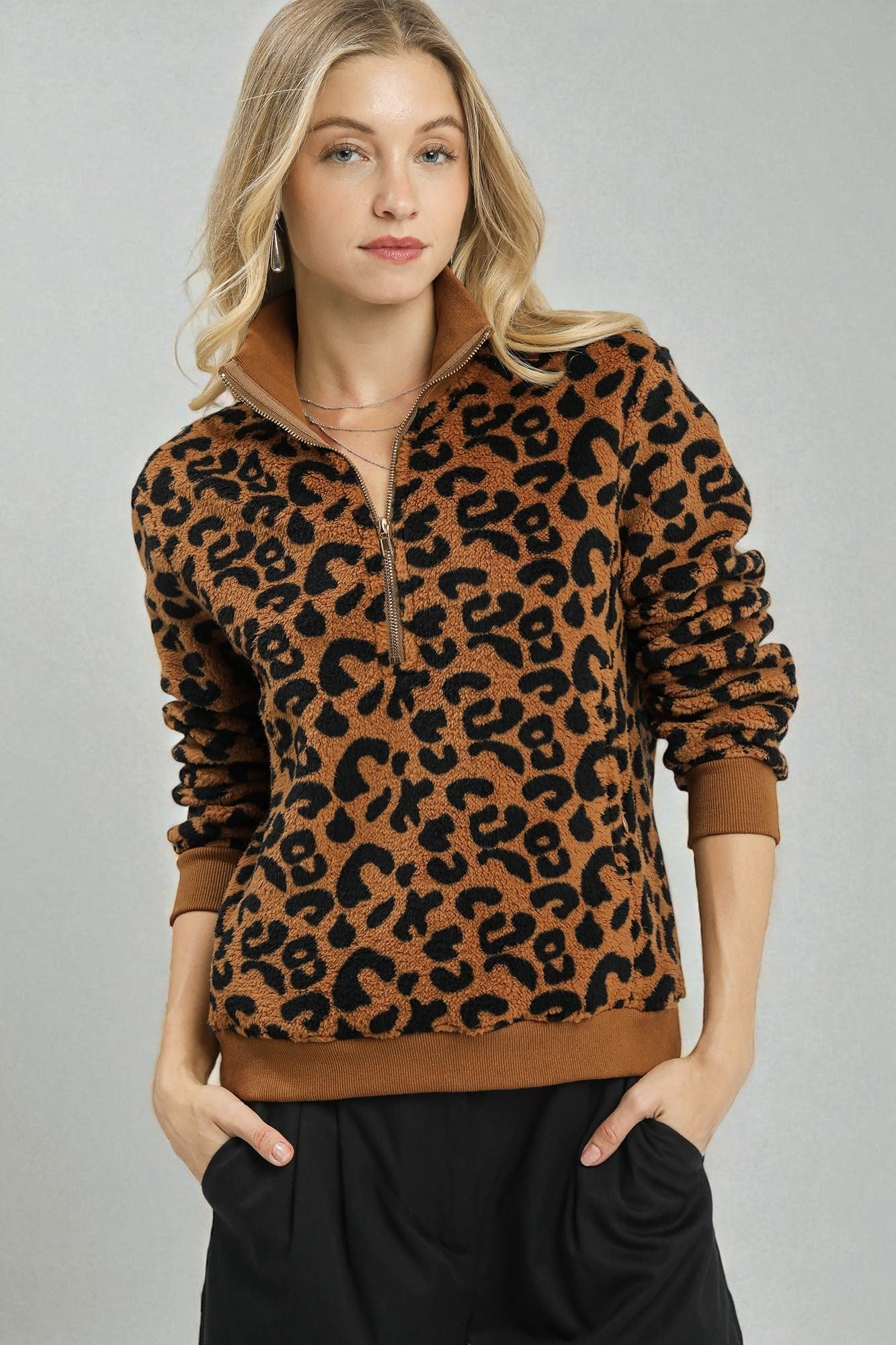 Woman wearing a leopard print sweater with a plain background