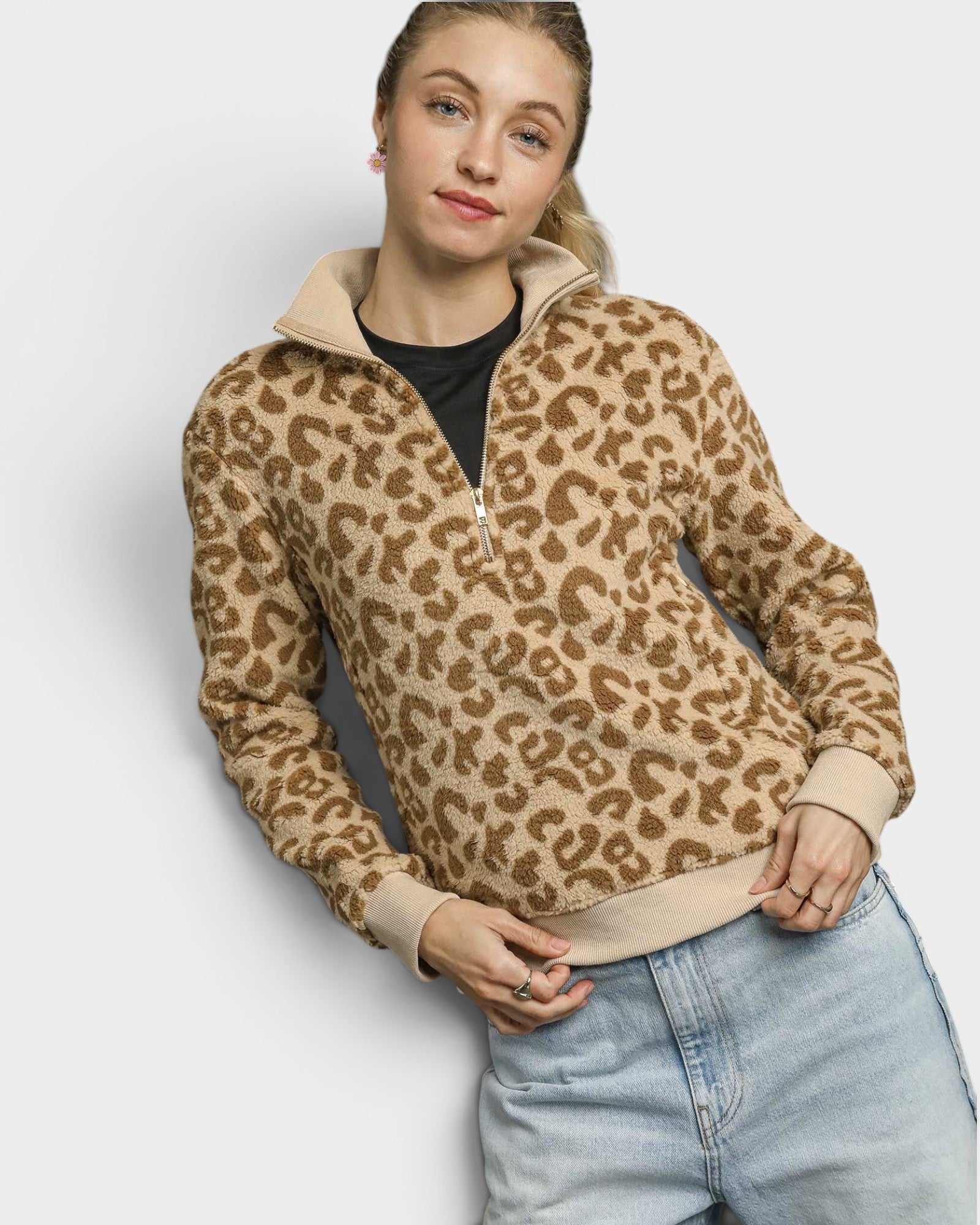 Person wearing a leopard print sweater with a plain background