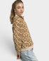 Woman wearing a leopard print sweater and light blue jeans on a white background