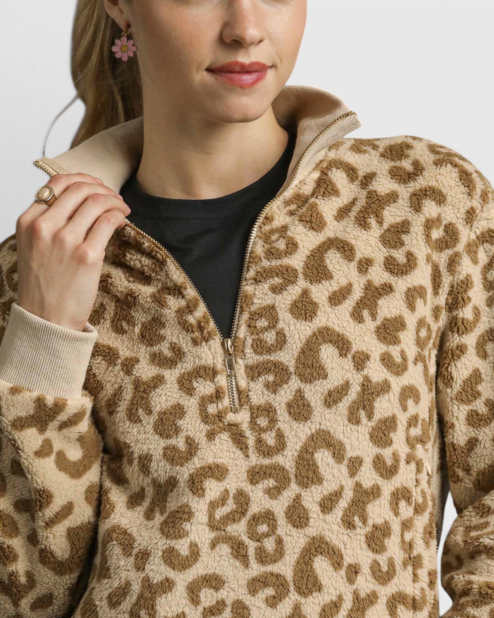 Person wearing a leopard print fleece jacket with a neutral background