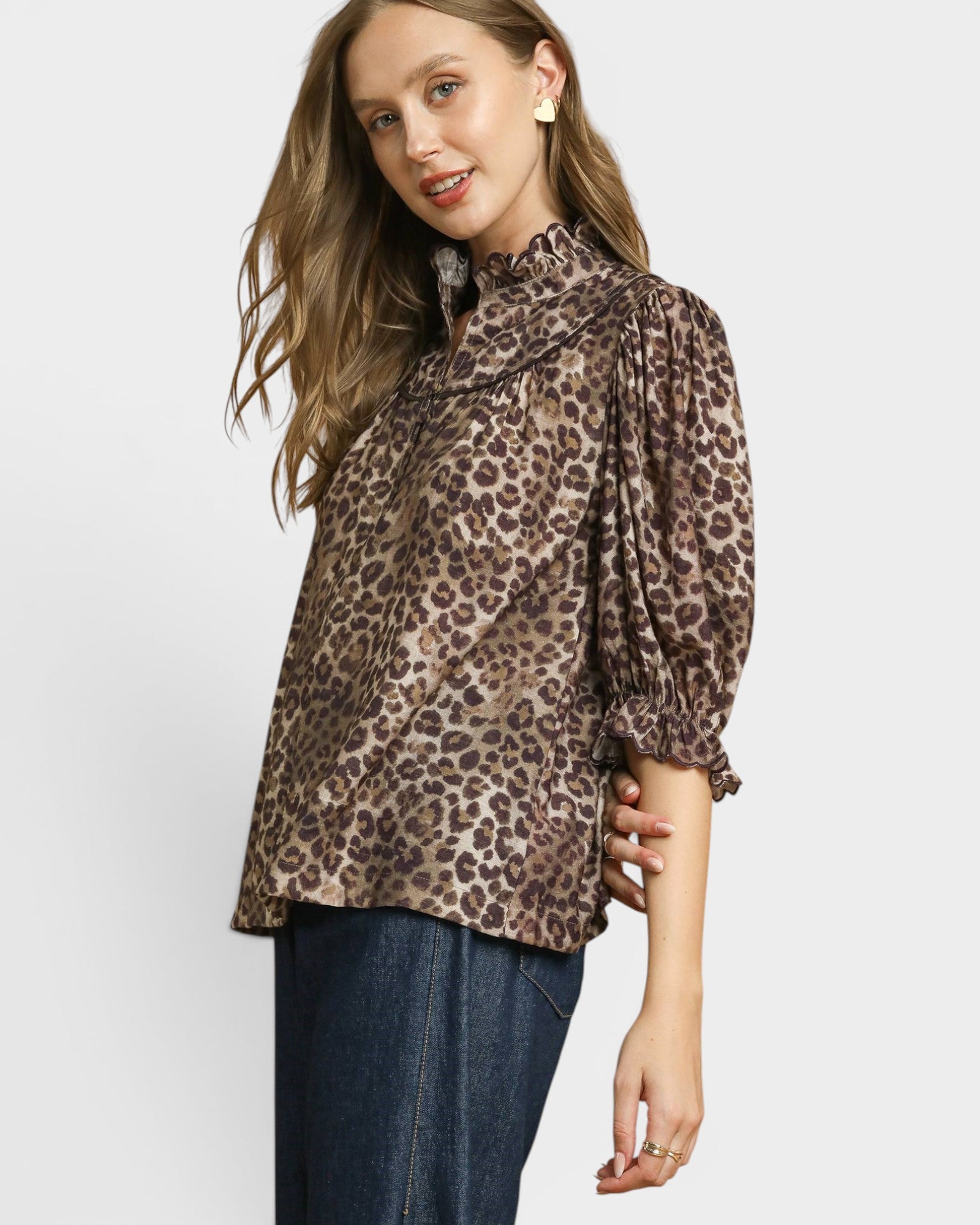 Woman wearing a leopard print blouse with long sleeves on a white background