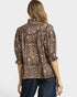 Woman wearing a leopard print blouse with a plain background